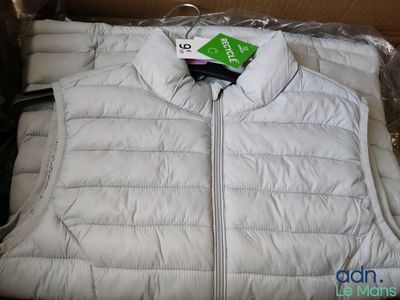 a white vest that is in a box with a tag on it