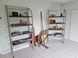 une pièce avec plein de livres et un râtelier à balais