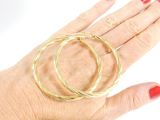 a woman ' s hand holding a pair of gold rings