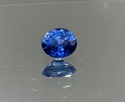 a close up of a blue sapphire stone on a reflective surface