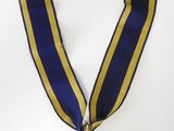 médaille d'or avec un ruban bleu et jaune sur fond blanc