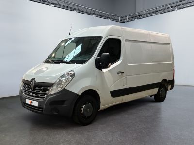 La camionnette blanche est garée dans une grande pièce au sol gris.