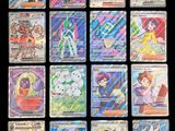 Les cartes Pokémon sont alignées sur une surface noire.