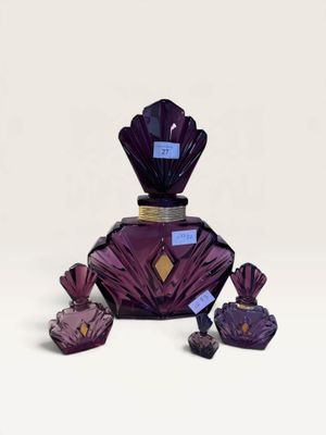 purple glass perfume bottle with purple crystals on a white surface