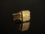 gros plan d'une bague en or sur une surface noire