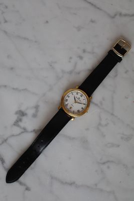 an image of a watch sitting on a marble counter top