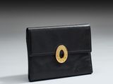 une image représentant un sac à main noir orné d'un anneau doré