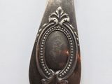 an old spoon with a picture on it sitting on a white surface