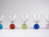 quatre verres à vin de couleurs différentes sont alignés en rangée