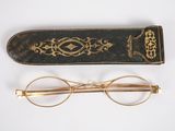 an old pair of glasses and a book on a white surface