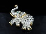 a close up of a gold and diamond elephant broochle
