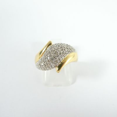 gros plan d'une bague en or et diamants sur une surface blanche