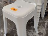 une pile de chaises en plastique blanc sur lesquelles est accrochée une étiquette de prix