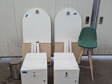 deux chaises blanches et une chaise verte devant un mur