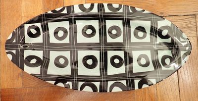 a black and white oval platter on a wooden floor