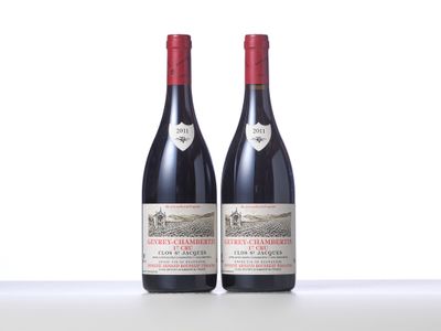 two bottles of red wine sitting on top of a table