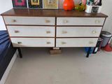 a white dresser with a wooden top in a room