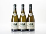 trois bouteilles de vin posées sur une table blanche