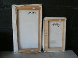 two picture frames sitting next to each other on a table