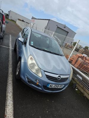 une voiture bleue garée sur un parking près d'une clôture