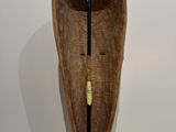 an old wooden canoe with a stick sticking out of it ' s side