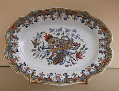 a plate with a bird design on it on a stand