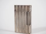 a silver lighter sitting on top of a white surface