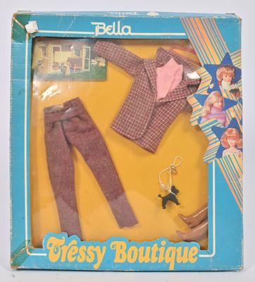 une poupée dans une boîte, avec des vêtements et des accessoires pour poupée