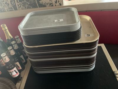 Plusieurs plateaux de nourriture sont empilés les uns sur les autres sur une table