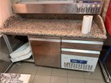une cuisine équipée d'un évier et d'un plan de travail sur lequel se trouve un rouleau de papier toilette