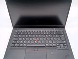 the laptop is open on a white surface with a red button on the keyboard