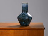 un vase bleu posé sur un meuble en bois