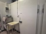 an image of a kitchen with a table and refrigerators