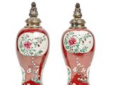 pair of red vases with floral designs on them on a white surface
