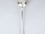silver spoon on a white surface with a tag on it