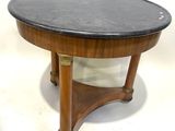 une table basse avec un plateau en marbre noir reposant sur un piètement en bois