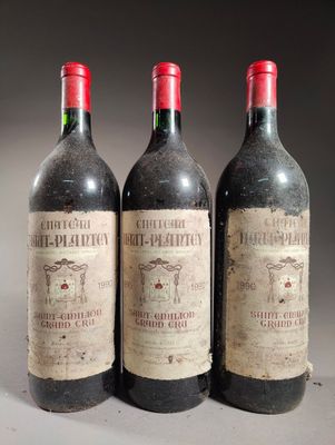 trois bouteilles de vin sont alignées sur une table