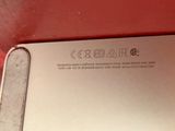 the back of a silver laptop computer sitting on top of a red table