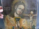 une vieille peinture représentant Jésus tenant un crucifix sur un fond bleu