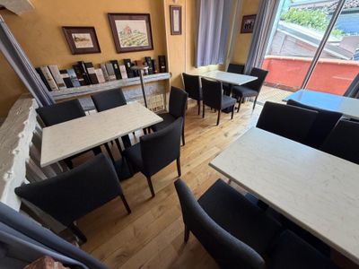 tables and chairs in a restaurant with a view of the city