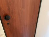 a wooden door with a black handle in a bathroom