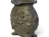 a small vase with a lid on a white background