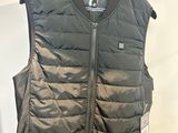 un gilet noir accroché à un cintre dans une pièce