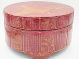 a red box with gold designs on it on a white surface
