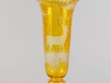 une image représentant un vase en verre jaune posé sur une table