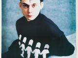 Cet homme porte un t-shirt noir orné de motifs blancs.
