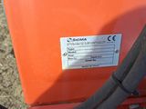 an orange machine with a black hose attached to it ' s side