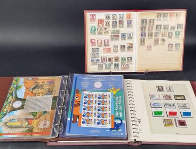 Trois livres sont ouverts sur une table, avec des timbres et des cachets dessus.