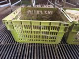 a green crate sitting on top of a metal grate