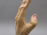 a clay sculpture of a hand holding something in it ' s right hand